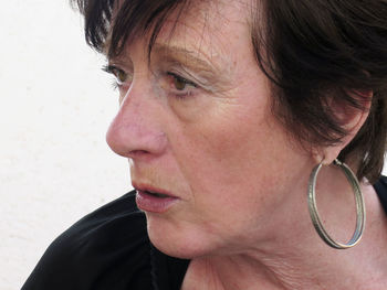 Close-up of woman looking away against wall