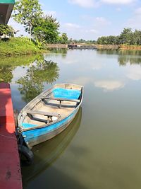 Boat moored in lake against sky