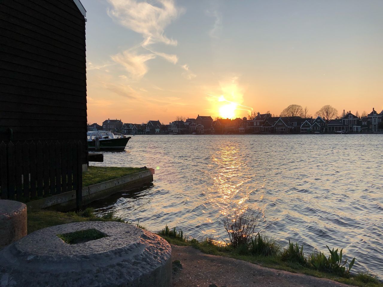 RIVER AMIDST BUILDINGS AGAINST SKY DURING SUNSET