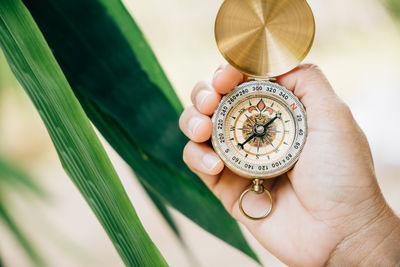 Cropped hand holding navigational compass