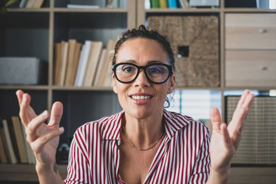 Portrait of smiling woman against book shelf