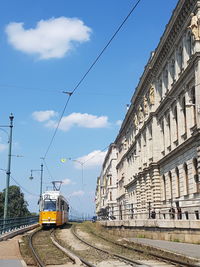 Railroad tracks in city against sky