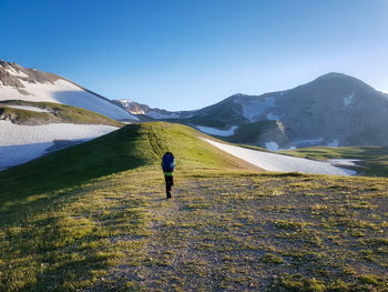 Trekking in mountains. tourist with backpack goes up mountain road. tourist goes up to caucasus