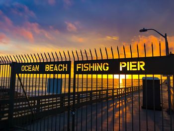 Information sign against sky during sunset