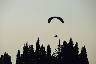 Low angle view of person paragliding against clear sky