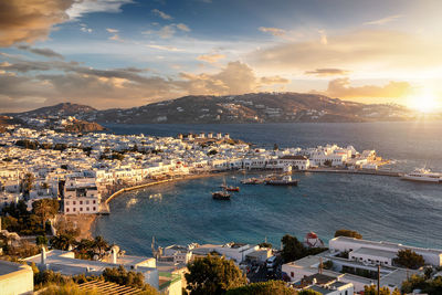 Aerial view of city by sea against sky