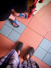 Low section of women standing on tiled floor