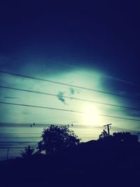 Low angle view of power lines against cloudy sky