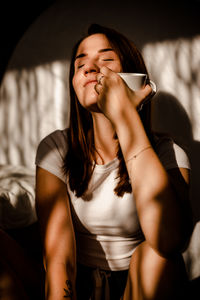 Midsection of woman with coffee at home