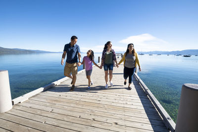 A family walks on a pier on a beautiful day in south lake tahoe, ca