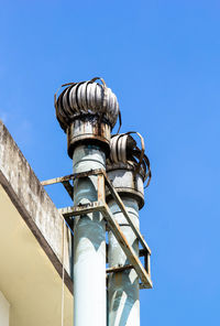 Low angle view of pole against building against clear blue sky