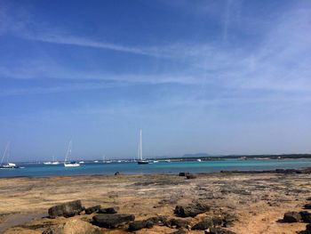 Sailboats on beach against sky