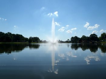 Fountain in lake against sky