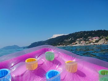 View of drink in water against clear blue sky