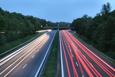 Light trails on highway against sky