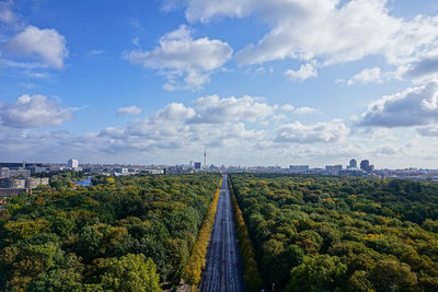 Panoramic shot of road amidst plants and trees against sky