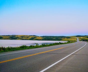 Road by landscape against clear sky