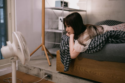 Rear view of woman sitting on sofa at home