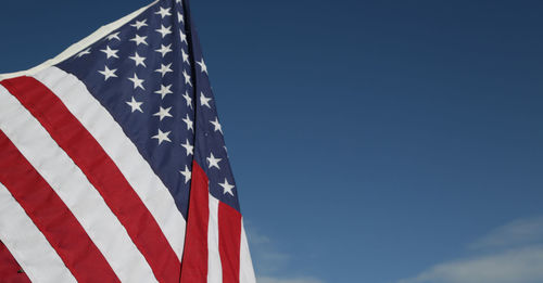 Low angle view of flag against blue sky