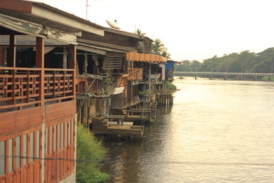 Buildings by river against clear sky