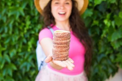 Portrait of woman holding pink food outdoors