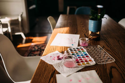 Palette of watercolor sitting on dining room table in window light