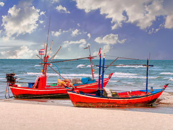 Wooden fishing boat on the beach/fishing boat on the beach under blue sky background in thailand.