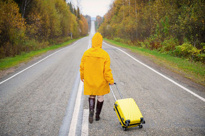 Rear view of man walking on road