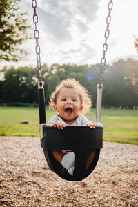 Portrait of boy on swing in playground