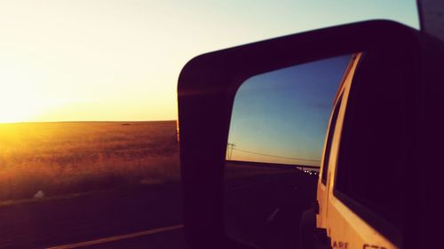 Car on desert against sky during sunset