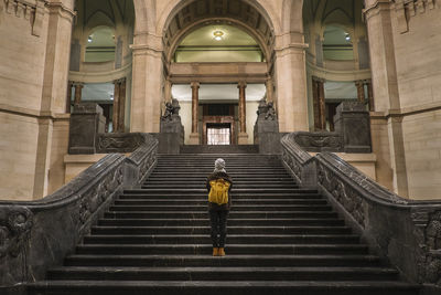 Rear view of woman standing on steps of city hall