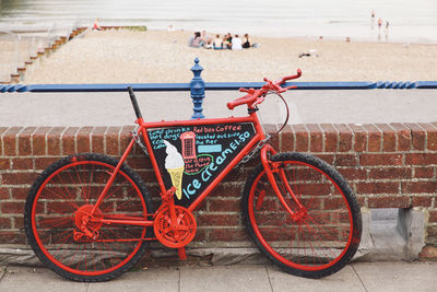 Bicycle parked by wall at beach