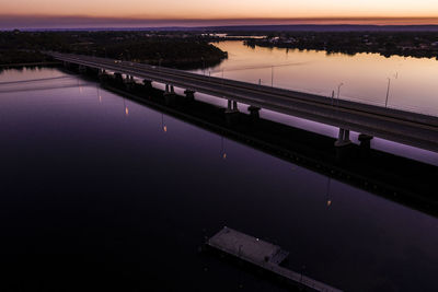 Bridge over river against sky during sunset