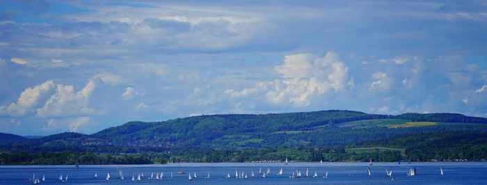 Scenic view of lake by mountains against sky