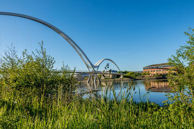 Arch bridge over river against clear sky