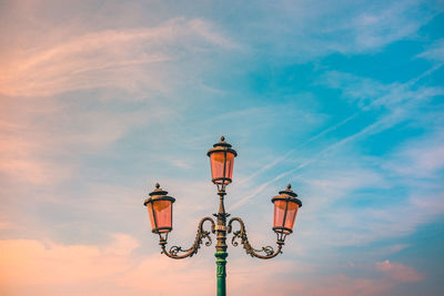 Low angle view of illuminated street light against sky