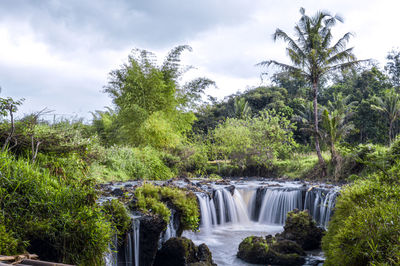 Scenic view of waterfall against sky