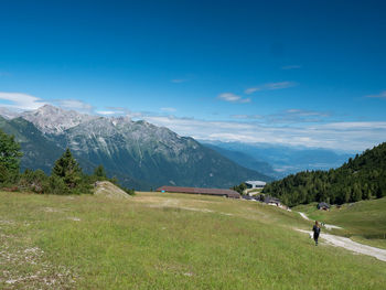 Rear view of man walking on field against sky