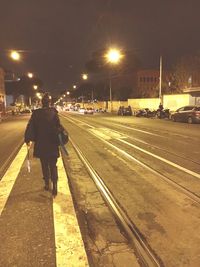 Railroad tracks in city at night