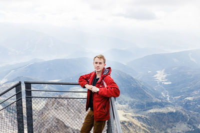 Millennial guy enjoys mountain views of alps from observation deck