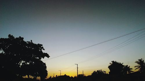 Low angle view of silhouette trees against clear sky