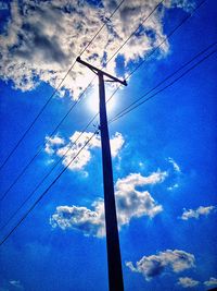 Low angle view of power lines against cloudy sky