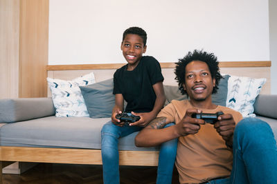 Father and son playing video game at home