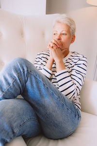 Young woman sitting on sofa at home