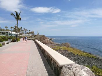 Footpath by sea against sky