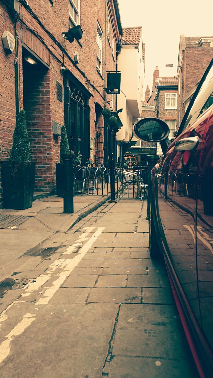 building exterior, architecture, built structure, the way forward, street, residential building, city, residential structure, building, cobblestone, house, diminishing perspective, incidental people, clear sky, outdoors, sunlight, empty, road, day, sidewalk