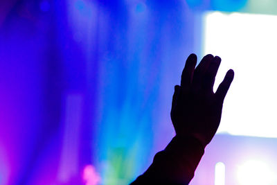 Close-up of silhouette hand against blue sky