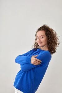 Portrait of smiling young woman against white background