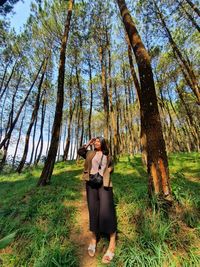 Woman standing by tree on field