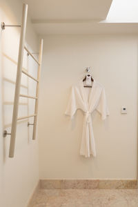 Clothes hanging on white wall at home